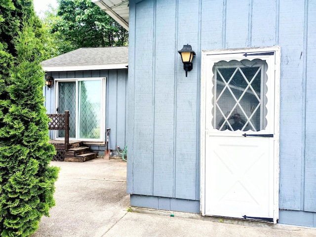 223 Mallard Ave, Houghton Lake, MI 48629 - view of exterior entry featuring roof with shingles and board and batten siding