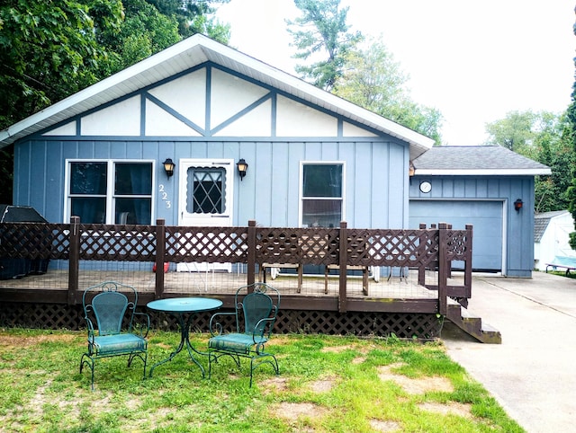 223 Mallard Ave, Houghton Lake, MI 48629 - rear view of property with board and batten siding, a deck, and concrete driveway