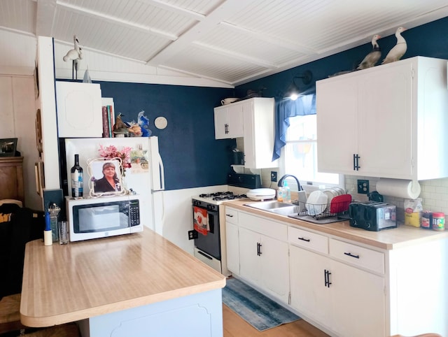 223 Mallard Ave, Houghton Lake, MI 48629 - kitchen with gas range oven, light countertops, and white cabinetry