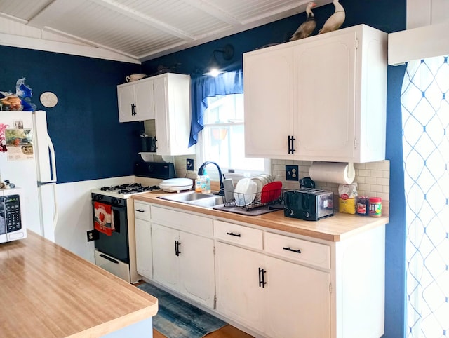 223 Mallard Ave, Houghton Lake, MI 48629 - kitchen featuring gas range, light countertops, tasteful backsplash, and white cabinets
