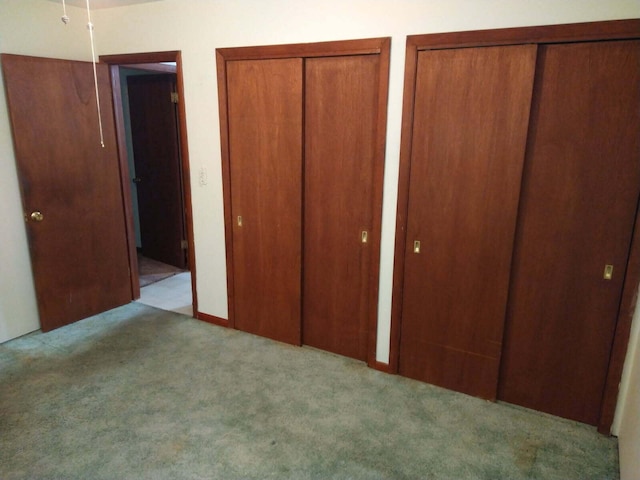 1427 E Lacomb Rd, Alpena, MI 49707 - unfurnished bedroom featuring multiple closets and carpet floors