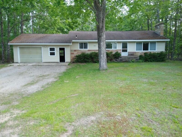 1427 E Lacomb Rd, Alpena, MI 49707 - ranch-style house with a chimney, an attached garage, a front yard, and driveway