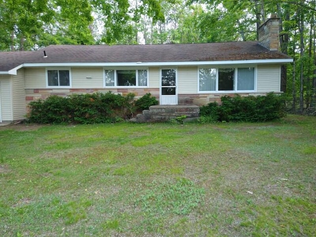 1427 E Lacomb Rd, Alpena, MI 49707 - single story home with a chimney and a front lawn