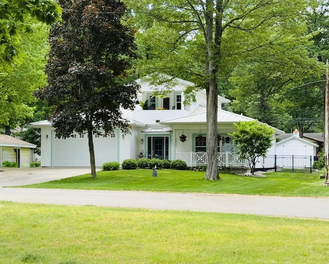129 Ethel Dr, Roscommon, MI 48653 - view of front of house with covered porch, a garage, driveway, and a standing seam roof