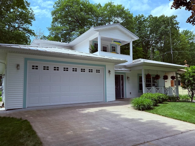 129 Ethel Dr, Roscommon, MI 48653 - view of front of house featuring a porch, concrete driveway, an attached garage, and a metal roof