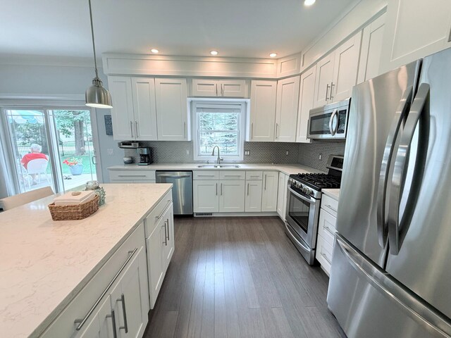 129 Ethel Dr, Roscommon, MI 48653 - kitchen with stainless steel appliances, decorative backsplash, white cabinets, pendant lighting, and recessed lighting
