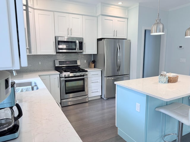 129 Ethel Dr, Roscommon, MI 48653 - kitchen with stainless steel appliances, backsplash, white cabinets, a breakfast bar area, and dark wood finished floors