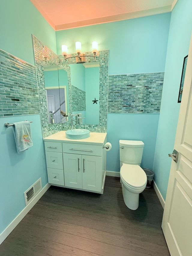 129 Ethel Dr, Roscommon, MI 48653 - bathroom featuring wood finished floors, tile walls, vanity, and decorative backsplash