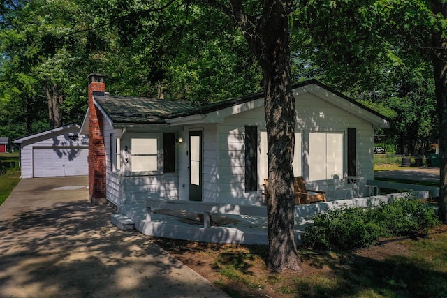 213 Devonshire Dr, Prudenville, MI 48651 - view of front of home with a chimney, an outdoor structure, and a detached garage
