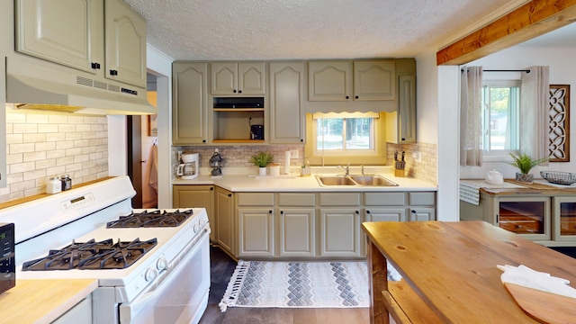 213 Devonshire Dr, Prudenville, MI 48651 - kitchen featuring gas range gas stove, under cabinet range hood, wood counters, a textured ceiling, and tasteful backsplash