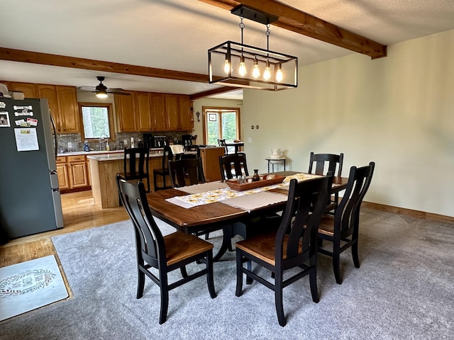 7984 US-23, Cheboygan, MI 49721 - dining area with beamed ceiling, ceiling fan, and light wood-style flooring