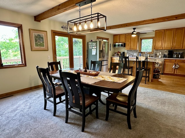 7984 US-23, Cheboygan, MI 49721 - dining space featuring light carpet, beamed ceiling, a ceiling fan, and a textured ceiling