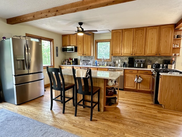 7984 US-23, Cheboygan, MI 49721 - kitchen featuring stainless steel appliances, open shelves, light wood-type flooring, decorative backsplash, and beam ceiling