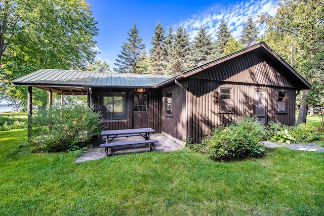 451 Gower Ln, Cheboygan, MI 49721 - view of front of house featuring a front yard, a chimney, and a metal roof