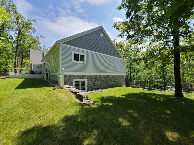 5825 Arawak Pass, Gaylord, MI 49735 - view of side of home with a yard, a wooden deck, and stone siding