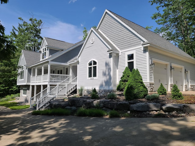 5825 Arawak Pass, Gaylord, MI 49735 - view of property exterior with a porch, stairs, a garage, and roof with shingles