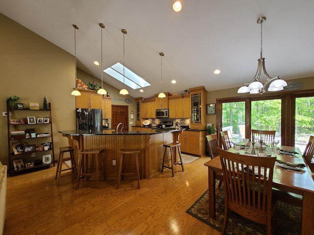 5825 Arawak Pass, Gaylord, MI 49735 - dining area with a skylight, light wood-style floors, lofted ceiling, and recessed lighting
