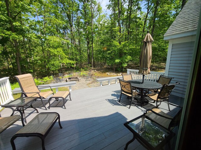 5825 Arawak Pass, Gaylord, MI 49735 - wooden deck featuring outdoor dining area and a fire pit