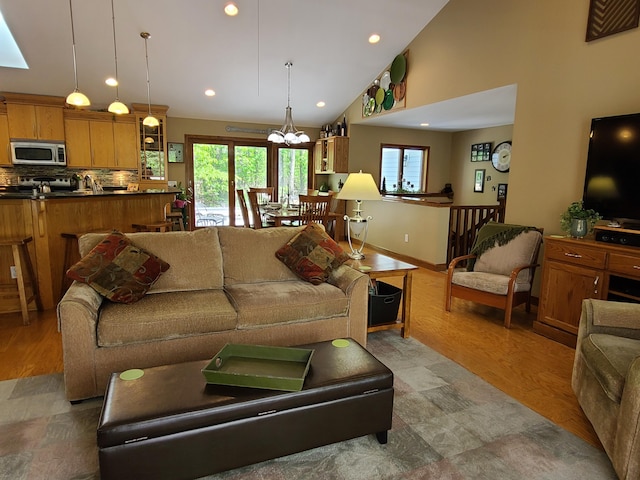 5825 Arawak Pass, Gaylord, MI 49735 - living area featuring vaulted ceiling, plenty of natural light, recessed lighting, light wood-type flooring, and a chandelier