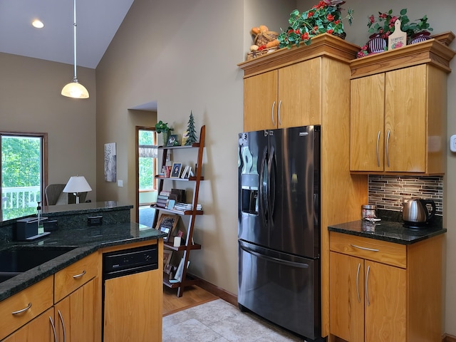 5825 Arawak Pass, Gaylord, MI 49735 - kitchen featuring refrigerator with ice dispenser, backsplash, dark stone countertops, high vaulted ceiling, and brown cabinetry