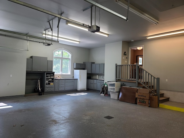 5825 Arawak Pass, Gaylord, MI 49735 - garage featuring freestanding refrigerator and a garage door opener