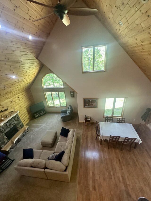 18440 Hardwood Trl, Hillman, MI 49746 - living room with high vaulted ceiling, wooden ceiling, wood finished floors, a ceiling fan, and a fireplace