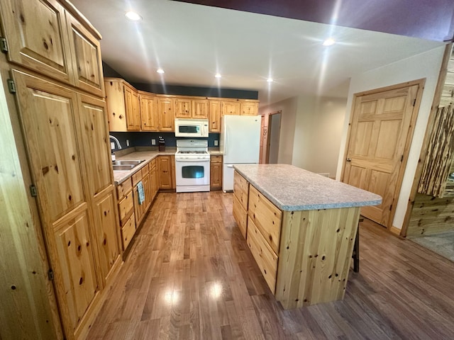18440 Hardwood Trl, Hillman, MI 49746 - kitchen with white appliances, light wood-style floors, light countertops, a kitchen island, and light brown cabinetry