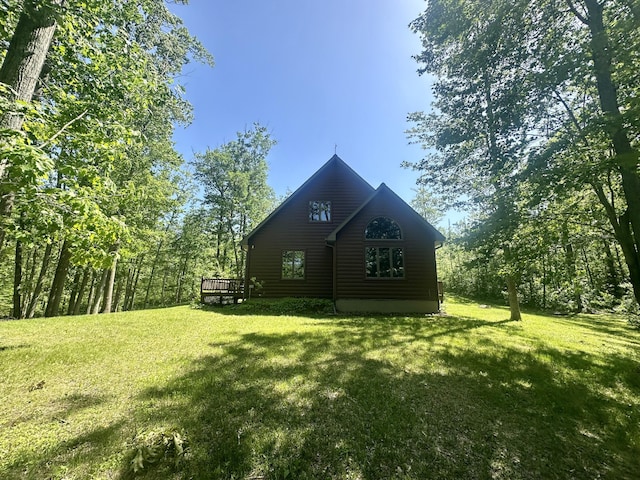 18440 Hardwood Trl, Hillman, MI 49746 - view of side of property featuring a yard, a deck, and faux log siding