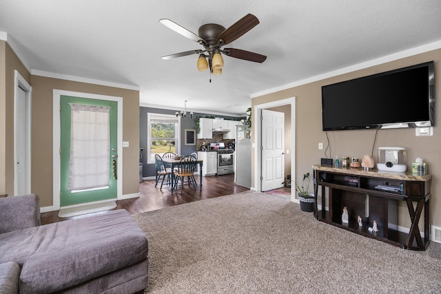 8934 Roberts Rd, Mancelona, MI 49659 - carpeted living area featuring ornamental molding, a ceiling fan, and a chandelier