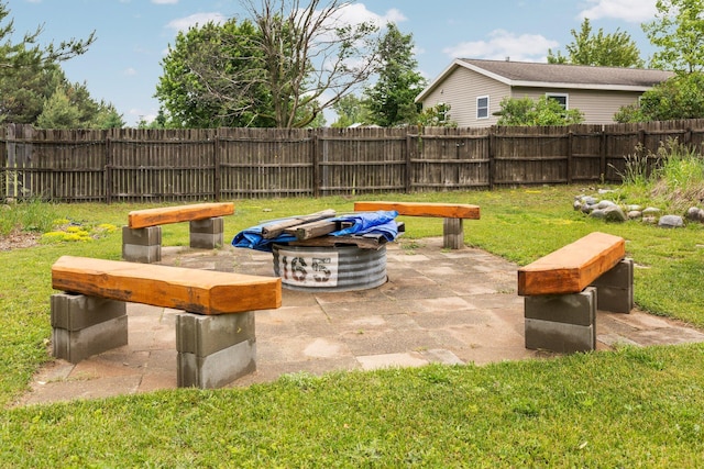 8934 Roberts Rd, Mancelona, MI 49659 - fenced backyard featuring a patio area and an outdoor fire pit
