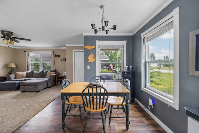 8934 Roberts Rd, Mancelona, MI 49659 - dining room featuring dark wood-style flooring, a chandelier, ornamental molding, and a ceiling fan