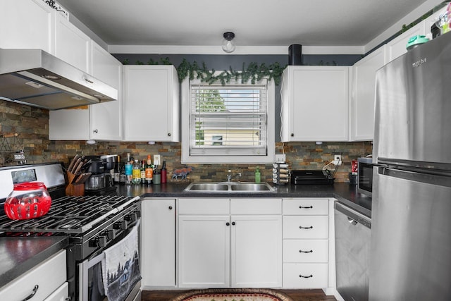 8934 Roberts Rd, Mancelona, MI 49659 - kitchen featuring appliances with stainless steel finishes, range hood, white cabinetry, and dark countertops