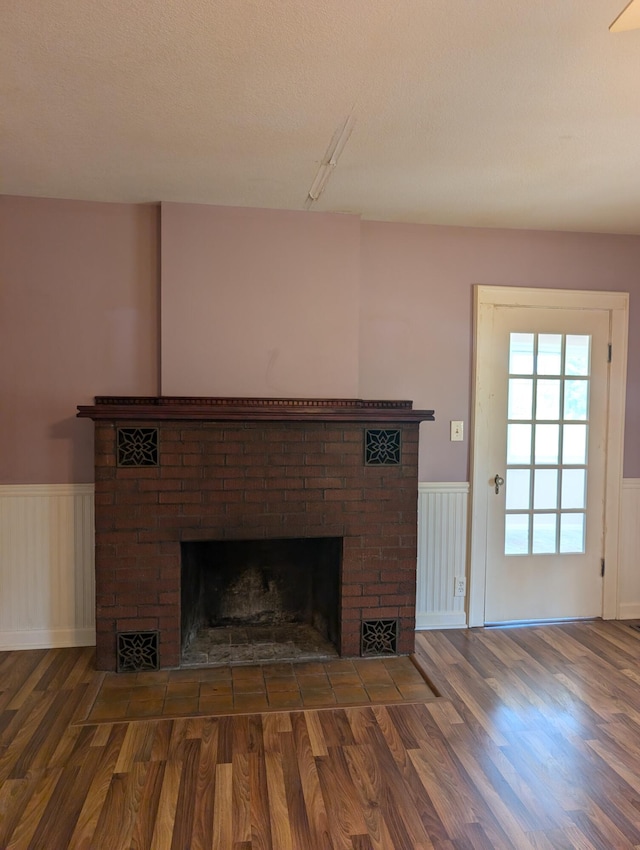3090 S 37th Rd, Cadillac, MI 49601 - unfurnished living room with a wainscoted wall, a brick fireplace, wood finished floors, and a decorative wall