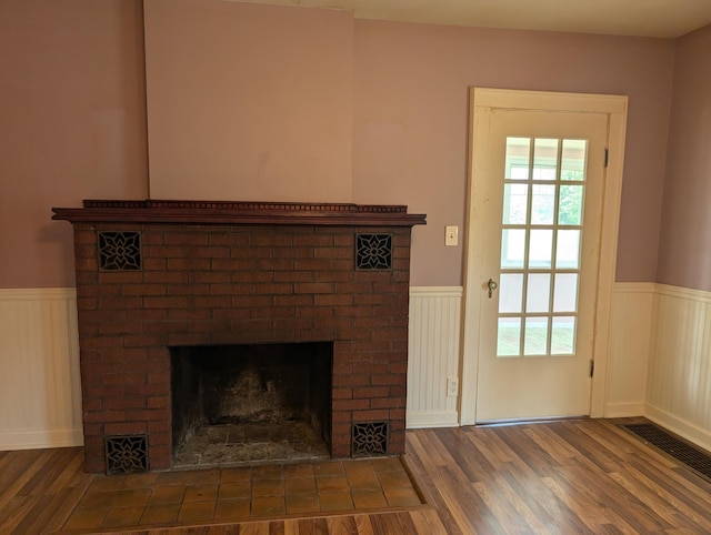 3090 S 37th Rd, Cadillac, MI 49601 - detailed view of a wainscoted wall, a brick fireplace, wood finished floors, and a decorative wall