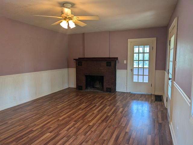 3090 S 37th Rd, Cadillac, MI 49601 - unfurnished living room with wainscoting, dark wood-type flooring, a ceiling fan, and a brick fireplace