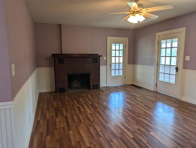 3090 S 37th Rd, Cadillac, MI 49601 - unfurnished living room featuring wainscoting, dark wood finished floors, a fireplace, and ceiling fan