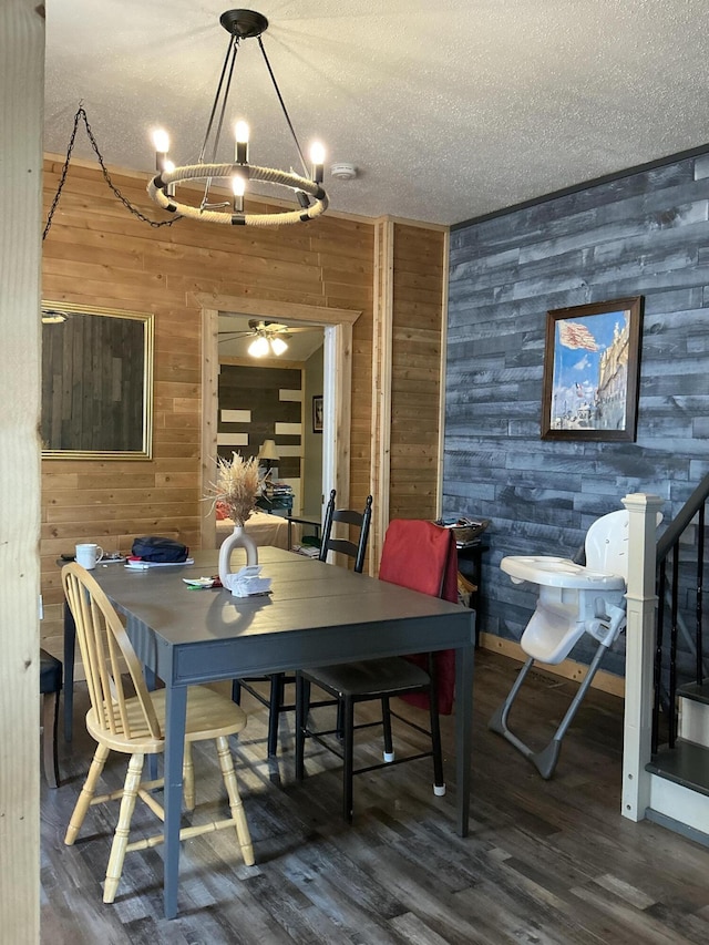 314 Sable St, Alpena, MI 49707 - dining area with wooden walls, a textured ceiling, wood finished floors, and a chandelier