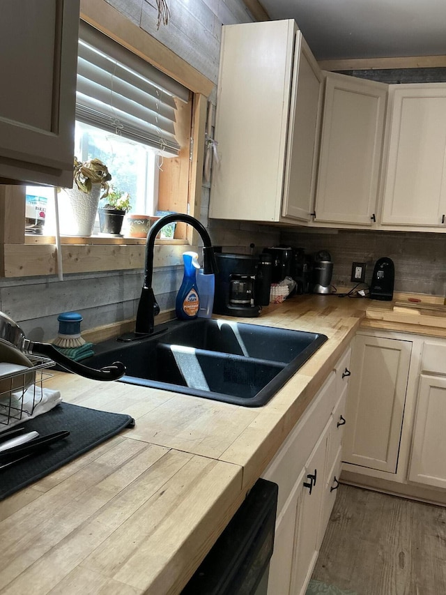 314 Sable St, Alpena, MI 49707 - kitchen with light countertops, backsplash, wood finished floors, and white cabinetry