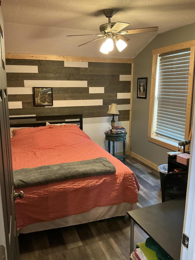 314 Sable St, Alpena, MI 49707 - bedroom with dark wood finished floors, wood walls, and vaulted ceiling