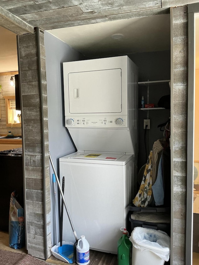 314 Sable St, Alpena, MI 49707 - washroom featuring stacked washer / dryer and wood finished floors