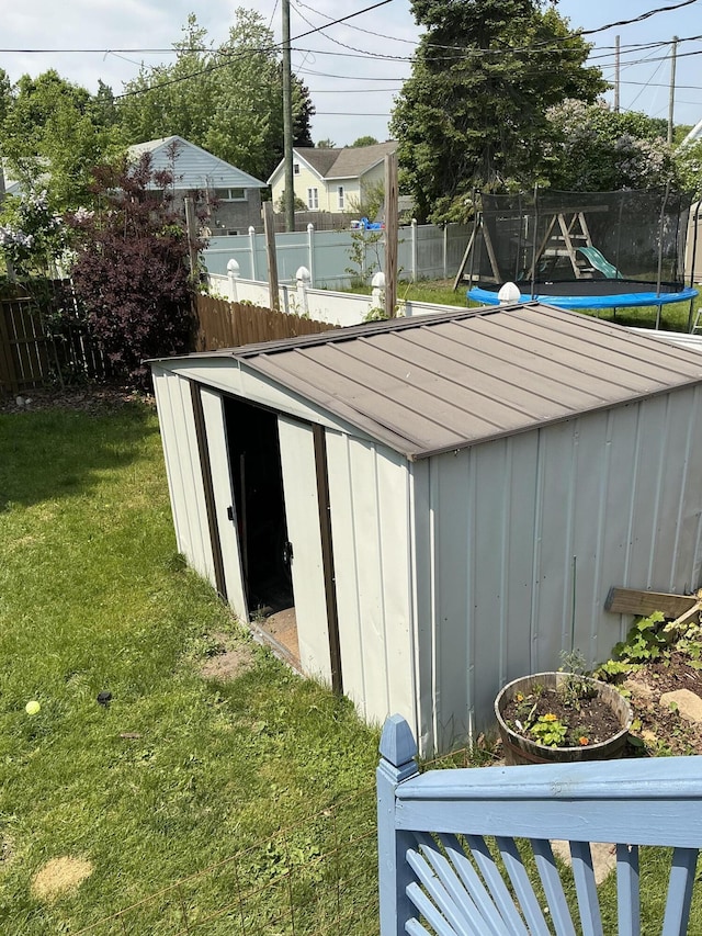 314 Sable St, Alpena, MI 49707 - view of outdoor structure featuring a trampoline, a fenced backyard, and a playground