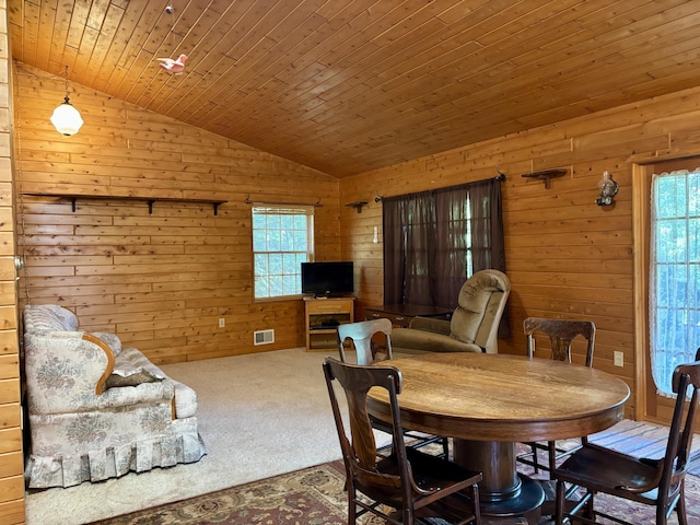 13333 S Black River Rd, Onaway, MI 49765 - dining room featuring vaulted ceiling, wooden walls, and carpet flooring