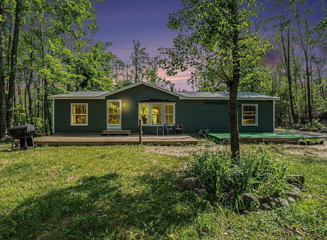 7539 E M-32, Johannesburg, MI 49751 - view of front of property featuring a lawn, a deck, and a metal roof