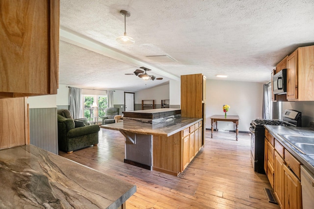 7539 E M-32, Johannesburg, MI 49751 - kitchen featuring stainless steel gas stove, a textured ceiling, open floor plan, lofted ceiling, and light wood-type flooring