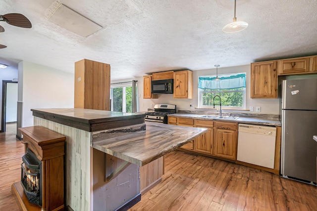 7539 E M-32, Johannesburg, MI 49751 - kitchen featuring appliances with stainless steel finishes, light wood-style flooring, a textured ceiling, wood counters, and hanging light fixtures