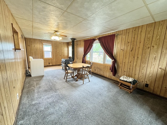2833 S Horseshoe Trl, Grayling, MI 49738 - dining space featuring plenty of natural light, wooden walls, carpet, and a wood stove