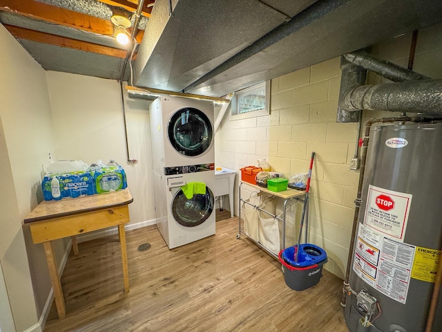 18680 Red Pine Dr, Hillman, MI 49746 - laundry room featuring gas water heater, stacked washer and clothes dryer, wood finished floors, and concrete block wall
