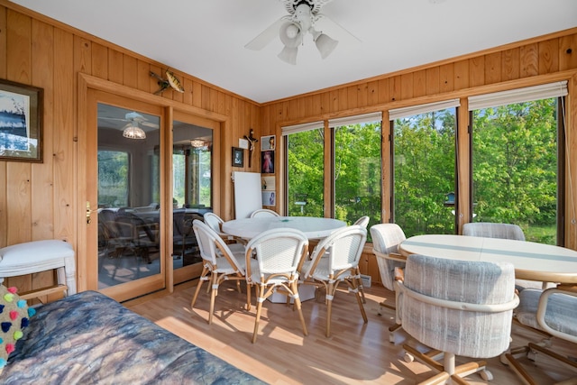 10134 Upper Mograin Rd, Cheboygan, MI 49721 - dining room with wooden walls, a ceiling fan, and wood finished floors