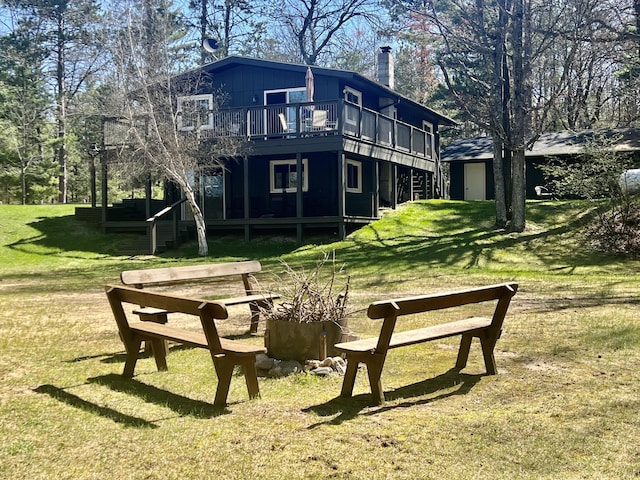 268 Yorke Trl, Grayling, MI 49738 - rear view of house with a chimney, a lawn, and a deck