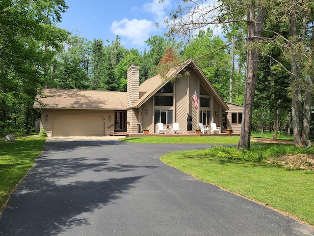1514 Opal Lake Rd, Gaylord, MI 49735 - view of front of property featuring driveway, a garage, a chimney, and a front lawn